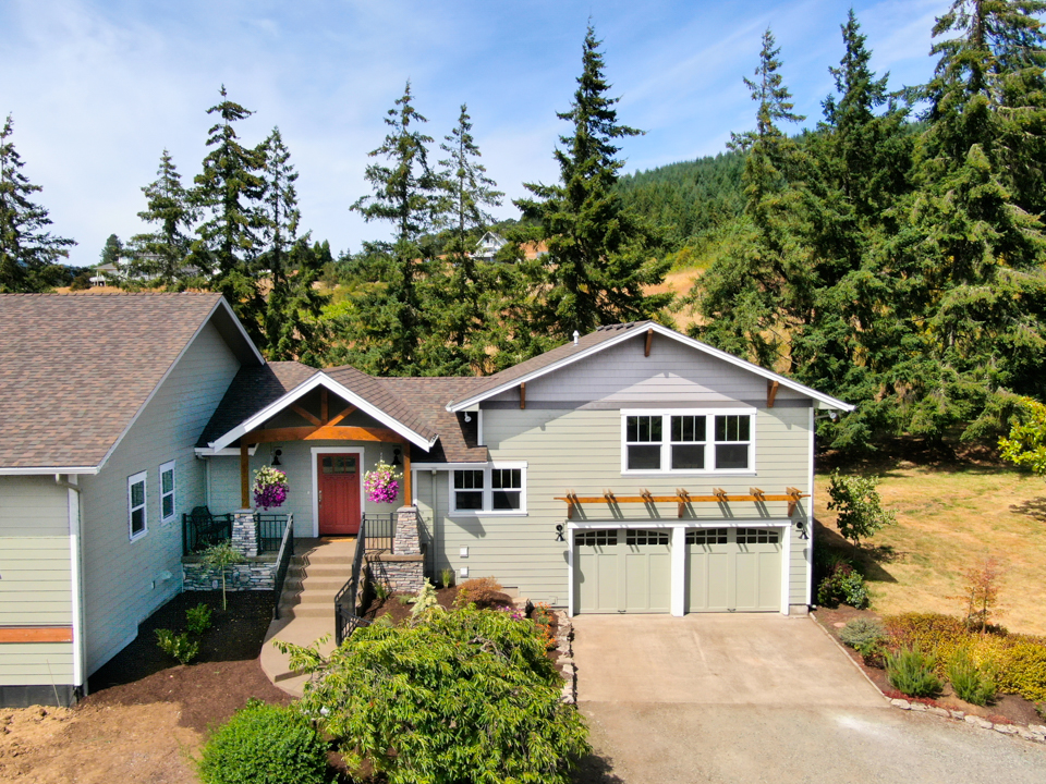A two-story home addition with a two-car garage, a red front door, and a covered entryway by Schweitzer Design & Build A two-story home addition with a two-car garage, a red front door, and a covered entryway by Schweitzer Design & Build