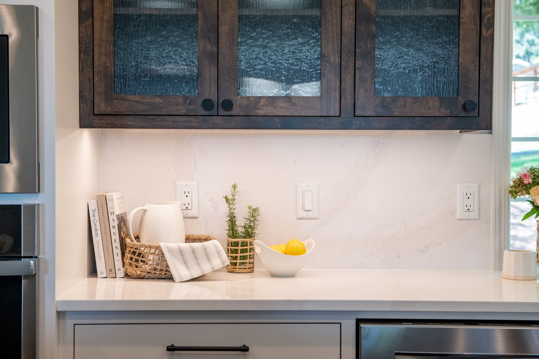 kitchen cabinets with white cabinets, brown cabinets with glass, white countertops in remodeled kitchen 